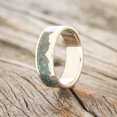 the wedding ring is made out of wood and has a green stone in it