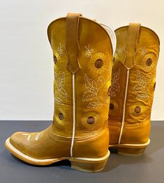 The Sunflower is built for durability with its Goodyear welt construction and leather sole. The unique stitching pattern, inspired by the flower itself, provides a striking visual aesthetic. From cowgirl to ranchers and any boot lover, the Sunflower is an ideal selection for anyone. **Here are just a few of the features that make the Sunflower so special:** All-leather Handcrafted construction Leather sole Beautiful stitching design pattern Durable and long-lasting Comfortable and stylish Country Style Hand Tooled Boots For Ranch, Country Style Hand-tooled Boots For Ranch, Country Style Fitted Moto Boots For Rodeo, Country Style Snip Toe Moto Boots For Rodeo, Country Style Fitted Moto Boots For Ranch, Fitted Country Style Moto Boots For Ranch, Country Style Moto Boots With Snip Toe, Hand Tooled Country Boots For Fall, Yellow Western Leather Boots