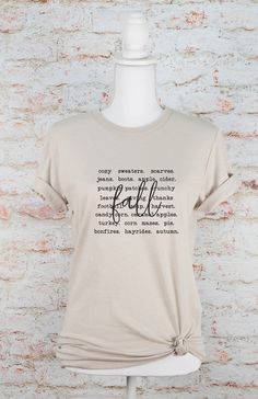 Fall Words Graphic Tee Combining comfort and style, the PLUS Fall Words Graphic Tee is the perfect addition to your wardrobe. Made with high-quality materials, this tee ensures long-lasting wear and comfort. With its trendy fall-inspired design, you'll be turning heads while expressing your love for the season. Upgrade your wardrobe with this must-have tee.100% combed and ring spun cotton Unisex Tee Comfortable Short Sleeve Tops For Fall, Fall Comfortable White Top, Trendy Comfortable Fit T-shirt For Fall, Trendy Comfort Fit T-shirt For Fall, Cotton Tops For Casual Gatherings In Fall, Fall Graphic Tee Soft-washed, Graphic Tee For Fall, Fall Crew Neck T-shirt With Relaxed Fit, Comfortable Graphic Tee For Fall