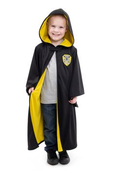 a young boy wearing a harry potter robe and smiling at the camera with his hands in his pockets