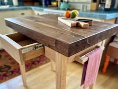 a wooden table with two drawers on each side and some napkins hanging from it