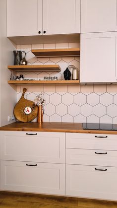 a kitchen with white cabinets and wooden counter tops