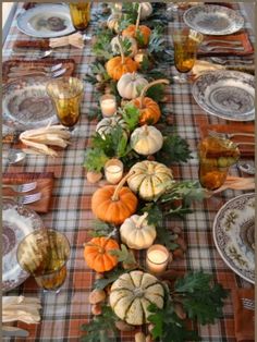 a long table is set with pumpkins and gourds