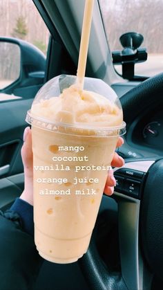 a person holding up a drink in their hand with the words mango smoothie on it