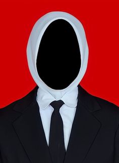 a man in a suit and tie with a hoodie on his head, standing against a red background