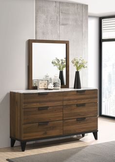 a wooden dresser with two vases and a mirror