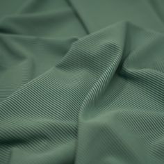 close up view of the texture of a bed sheet that has been made in green