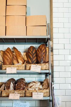 breads and loaves on shelves in a bakery