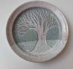 a white plate with a tree painted on it