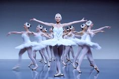 a group of ballerinas standing around each other