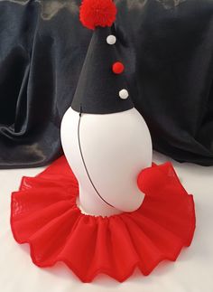 a white ballerina with a black top and red tutu skirt on a bed