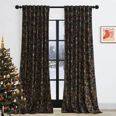 a christmas tree in front of a window with curtains hanging on the windowsills