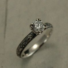 a close up of a ring with a diamond in it on the ground and concrete