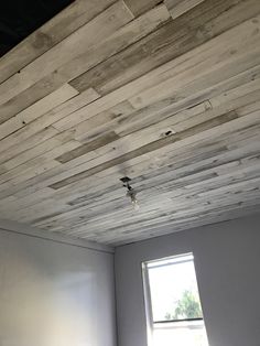 an unfinished room with white walls and wood planks that have been stripped off from the ceiling