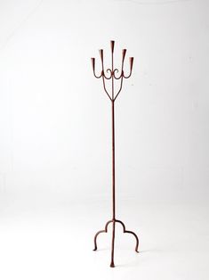 a metal coat rack with three candles on it