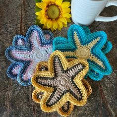 three crocheted starfish coasters next to a coffee cup and sunflower