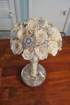 a vase filled with white flowers on top of a wooden table