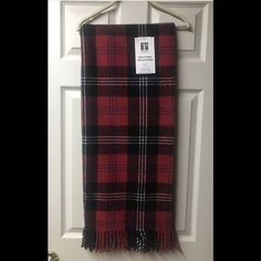 a red and black plaid blanket hanging on the front door with a price tag attached to it