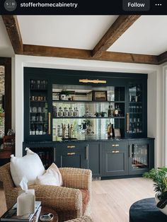 a living room filled with furniture and lots of bottles on top of the cabinet doors