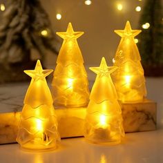 three lighted christmas trees sitting on top of a table