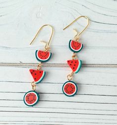 watermelon slice dangle earrings with gold earwires on white wooden background