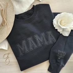 The ideal present for a mom is our super soft mama sweatshirt! It boasts a minimalistic, embossed puff design that exudes both comfort and style, making it perfect for home and running around. To make it even more unique, personalize the left (outside) sleeve with the children's names, adding a special touch that mom will cherish. We offer a beautiful selection of sweatshirt colors and puff wording colors. SHOWN IN MAIN PICTURE - BLACK w/ BLACK PUFF Sizes: SM - 2XL (We do carry some colors in 3X Black On Black Puff Vinyl, Diy Sweatshirt Ideas Vinyl, Black On Black Sweatshirt, Mama Puff Vinyl Sweatshirt, Diy Sweatshirt Ideas Iron On, Mother's Day Black Crew Neck Sweatshirt, Puffy Vinyl Sweatshirt, Casual Black Sweatshirt For Mother's Day, Cricut Sweaters