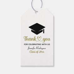 a white thank tag with gold lettering and a black graduation cap on the top, says thank you for celebrating with us