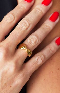 a woman with red nails and a gold ring