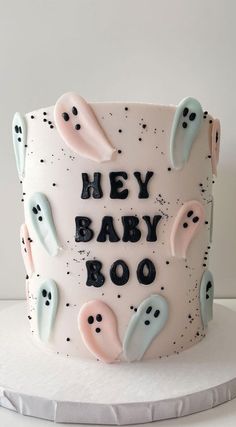 a white cake with frosting that says hey baby boo on it and ghost decorations