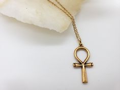 The Egyptian Ankh symbolizes life, protection & eternity. Its power was believed to protect the dead and ensure eternal life. Wear a piece of Ankh jewelry for protection, a reminder of the past, or just as an accessory. Materials: 1” pewter charm with 18" gold plated brass chain Made in USA Antique Gold Symbolic Engraved Jewelry, Adjustable Brass Cross Jewelry, Symbolic Engraved Antique Gold Jewelry, Adjustable Brass Cross-shaped Jewelry, Spiritual Metal Necklaces, Spiritual Bronze Jewelry With Oxidized Finish, Symbolic Metal Necklaces With Antique Finish, Spiritual Bronze Metal Jewelry, Bronze Spiritual Jewelry For Blessing