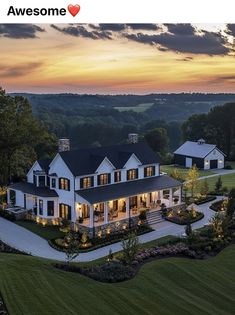 an aerial view of a large white house with lots of windows and landscaping at sunset