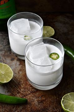 two glasses filled with ice and lime slices