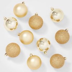 gold and white ornaments are arranged on a white surface