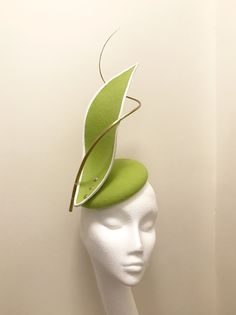 Handmade and hand stitched rounded base headpiece, in light fresh green wool felt, stiffened to give clean structure. Bonded with white grosgrain wired edging, screwed in with metal gold sprayed screws and gold sprayed ostrich feather quills once heated and hand curled. A unique creation made with Spring Mini Hat With Round Crown, Modern Fitted Hats For Spring, Green Adjustable Felt Hat For Kentucky Derby, Green Short Brim Felt Hat For Kentucky Derby, Green Fitted Headpiece For Royal Ascot, Fitted Green Brimmed Felt Hat, Green Fitted Brimmed Felt Hat, Fitted Cloche Felt Hat For Spring, Spring Fitted Cloche Felt Hat