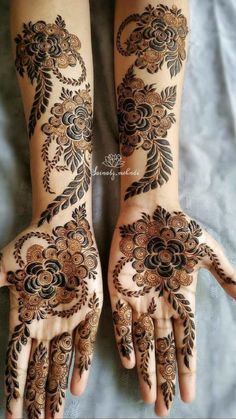 two hands with henna designs on them