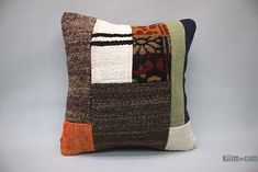 a multicolored patchwork pillow on a gray background