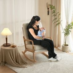 a woman sitting in a rocking chair holding a baby