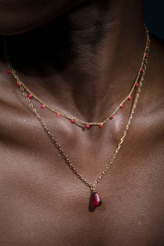 Anet's Collection seed of life single pomegranate seed Necklace in Gold paired with red dotted necklace. In Armenian mythology the pomegranate symbolizes fertility and abundance. The fruit is the Armenian symbol of life and tradition tells us that each mature pomegranate has 365 seeds, one for each day of the year. Length: 16" & 18" Pom seeds: Formica 2mm 14 K gold plated double necklace, can be used separately or together Brass casting Red Polished Beads Necklace For Meditation, Amulet Style Beaded Chain Necklaces As Gift, Amulet Style Beaded Chain Necklaces For Gifts, Bohemian Necklace With Satellite Chain For Gifts, Bohemian Necklace With Satellite Chain, Festive Red Coral Necklace, Red Necklaces With Round Beads For Meditation, Spiritual Red Coral Jewelry, Red Double Strand Beaded Chain Jewelry