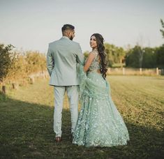 a bride and groom standing in the grass