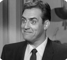 a man in a suit and tie making a funny face with his eyes wide open