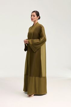 Elevate your wardrobe with the Estee Viscose Open Abaya in Olive Night. Crafted from luxurious viscose, this stunning abaya features elegant flare sleeves and a unique sheer design with solid viscose trim. Breathable and luxurious, this abaya will be your new go-to for sophisticated and exclusive style. Model is 5'7" and is wearing size XS/58". Cotton Abaya, White Dress Formal, Dresses Flowy, Nikkah Dress, Open Abaya, Flare Sleeves, Engagement Dresses, Kids Outerwear, Bamboo Silk