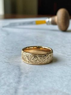 a gold wedding band sitting on top of a table