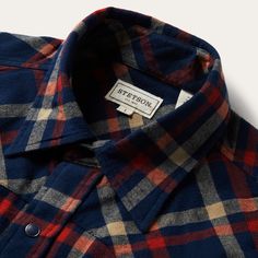 This rugged flannel shirt features a rich navy blue plaid print. Authentic Western details include a snap front, one-point curved back yoke and a three snap cuff. A spread collar with collar stays keeps the shirt looking sharp, while subtly embossed Stetson logos on the chest pocket and sleeve placket further augment the style. It’s made from a garment washed brushed twill flannel that hangs well while keeping its shape and only gets better with age. Brushed Twill Flannel One-Point Curved Back Y Fitted Plaid Flannel Shirt With Spread Collar, Fitted Plaid Flannel Shirt With Button Closure, Classic Navy Shirt For Fall, Blue Shirt With Snap Buttons For Fall, Fall Blue Shirt With Snap Buttons, Collared Plaid Shirt With Snap Buttons, Plaid Shirt With Placket For Fall, Classic Collared Flannel Shirt With Snap Buttons, Plaid Collared Flannel Shirt With Button Closure