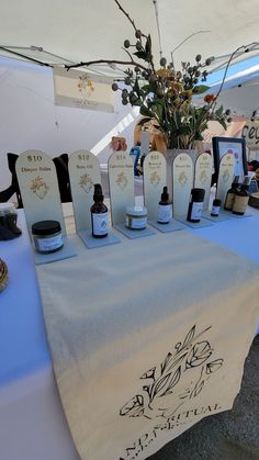 a table topped with bottles of different types of skin care products on top of a blue table cloth