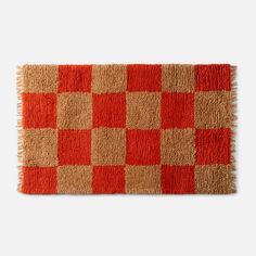 an orange and brown rug with squares on it, in the shape of a checkerboard