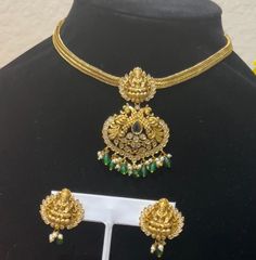 Make a statement with this stunning gold replica necklace set, featuring intricate detailing and adorned with emerald beads and Polki stones. The set includes a beautifully designed choker-style necklace with a large pendant and matching earrings, perfect for special occasions or traditional events. Gold Kundan Necklace With Emerald For Wedding, Gold Kundan Necklace With Emerald, Gold Emerald Kundan Necklace For Weddings, Gold Emerald Bridal Necklace, Gold Bollywood Necklaces With Jewels, Traditional Gold Jewelry Sets With Jewels, Gold Chandbali Bridal Necklace Jeweled, Gold Jeweled Bollywood Temple Necklace, Gold Jeweled Temple Necklace For Festivals