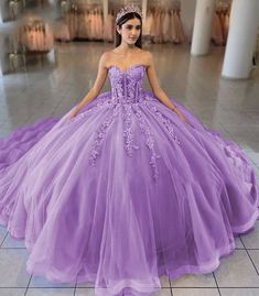 Turn your quinceanera into a fairytale with this exquisite ball-gown style dress. This dress is designed in airy tulle and available in dreamy colors like sky blue, lilac, and pink. The sweetheart neckline beautifully frames the shoulders and neckline, enhancing your look with a touch of romance. Adorned with intricate appliques and delicate 3D floral embellishments, this dress brings an enchanting garden to life. The lace-up back ensures a perfect fit, while the sleeveless design allows for gra Lilac And Pink Quinceanera Dresses, Organza Ball Gown Quinceanera Dress For Sweet 16, Organza Quinceanera Ball Gown For Sweet 16, Organza Ball Gown For Sweet 16, Purple Tulle Ball Gown For Quinceanera, Tulle Quinceanera Dress For Debutante Ball, Purple Tulle Quinceanera Ball Gown Dress, Purple Tulle Ball Gown Quinceanera Dress, Lavender Tulle Dress For Quinceanera