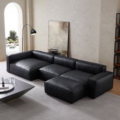 a black leather sectional sofa sitting on top of a gray carpeted living room floor