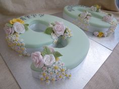 two cakes decorated with flowers on top of each other