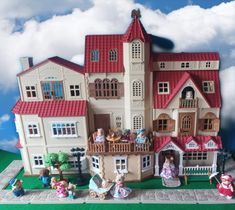 a large doll house with many dolls on the front and side windows, including children's toys